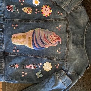 Girls Jean jacket decorated with patches and rhinestones.